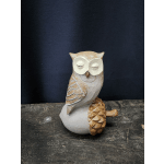 Small carved owl figurine on a dark surface