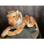 Plush tiger toy lying on a patterned cushion