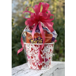 Heart-patterned gift bucket filled with candy and topped with a pink ribbon bow