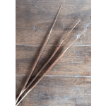 Three brown cattail stems on a wooden surface