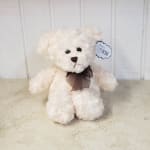 White teddy bear with a dark ribbon bow