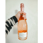 Hand holding a rose-gold sparkling wine bottle
