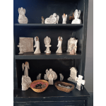 Shelf of angel figurines and memorial plaques with candles and baskets