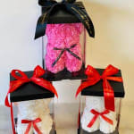 Gift boxes with rose-shaped arrangements in clear cylinders