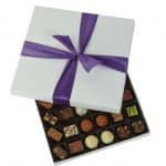 Box of assorted chocolates with a purple ribbon