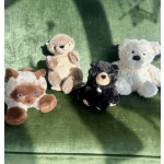 Four plush teddy bears sitting on a green fabric surface
