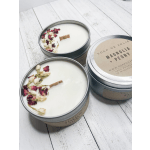 Two floral-scented candles in metal tins with dried petals on top