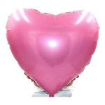 Large pink heart-shaped balloon held in front of a person