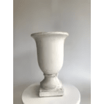 White decorative urn on a round pedestal