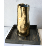 Gold metallic vase on a dark wooden tray