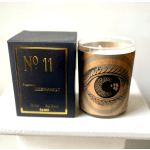 A boxed candle sits beside a glass jar candle with an eye design.