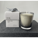 Boxed candle beside a glass candle in a black container