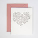 Floral heart design on a white card with a pink envelope