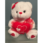 White teddy bear holding a red heart pillow