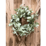 A leafy green wreath on a wooden background.