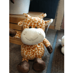 Plush giraffe toy with orange spots and a smiling face