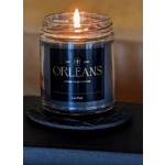 Lit candle in a glass jar with a dark label