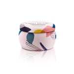 Decorative scented candle in a patterned tin container