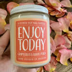 Soy wax candle in a glass jar surrounded by pink peach petals