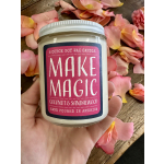 Handheld soy candle jar surrounded by pink rose petals