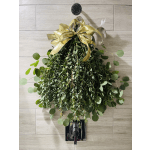 Hanging greenery arrangement with a gold bow and black wall hook