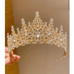 Gold jeweled tiara with clear crystals held in a hand