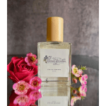 Perfume bottle beside a red rose and small pink flowers