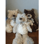 Three plush teddy bears with polka-dot bows sit together