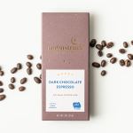 Box of dark chocolate espresso with coffee beans scattered around it