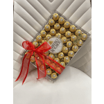 Box of Ferrero Rocher chocolates tied with a red ribbon