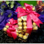 Two gift boxes of chocolates tied with bright pink ribbons