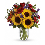 Bouquet of sunflowers, red roses, and purple flowers in a clear glass vase