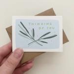 Hand holding a thinking of you greeting card with an envelope