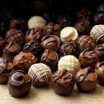 Assorted chocolate truffles with decorative tops arranged in a box