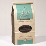 Bag of dark chocolate covered graham crackers standing on a light surface