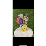 Yellow smiley-face mug filled with assorted candy bars