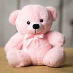 Pink plush teddy bear with a satin bow
