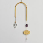 Gold U-shaped hanging ornament with crystal drops, purple bead, and etched eye charm