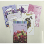 Five sympathy greeting cards with floral designs are fanned out on a light surface.
