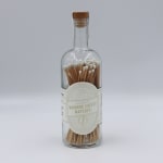 Glass bottle filled with wooden matches and a cork stopper