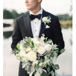Groom in a tuxedo holding a white floral bouquet