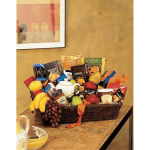Large wicker gift basket filled with assorted gourmet snacks and fresh fruit on a table