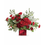 Red roses and carnations arranged in a red glass vase
