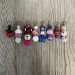 Decorative beaded picks with heart-shaped toppers arranged on a wood surface.