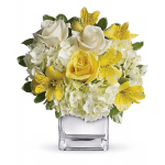 Yellow and white flower arrangement in a clear square vase