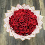 Large bouquet of red roses wrapped in pink and white paper