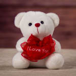 White teddy bear holding a red heart with "I Love You" text
