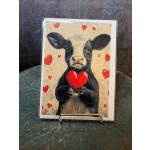 Greeting card with a calf holding a red heart and small heart decorations