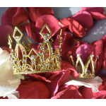 Gold jeweled tiara resting on red and white rose petals