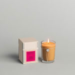 Lit candle in a glass tumbler beside its box